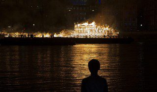 epa05524582 A boy watches as a sculpture of 17th Century London set on barges in the Thames River is set alight to mark the 350th anniversary of the Great Fire of London, in central London, Britain, 04 September 2016. The sculpture is a 120-meter-long, designed by US artist David Best and its lighting marks the end of festivities marking the Great Fire of London for four days in September 1666, that destroyed the majority of the city. EPA/WILL OLIVER